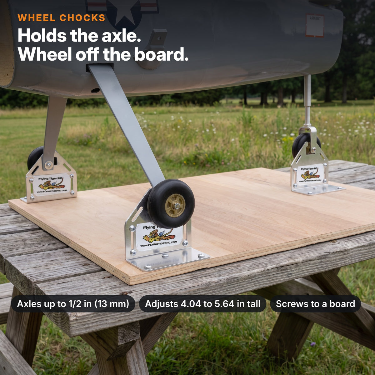 Wheel chock brackets holding a model airplane's wheels off a board at the flying field