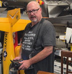 Pilot holding the Flying Tiger RC transmitter tray on the shoulder harness with a radio mounted, no hand pads fitted